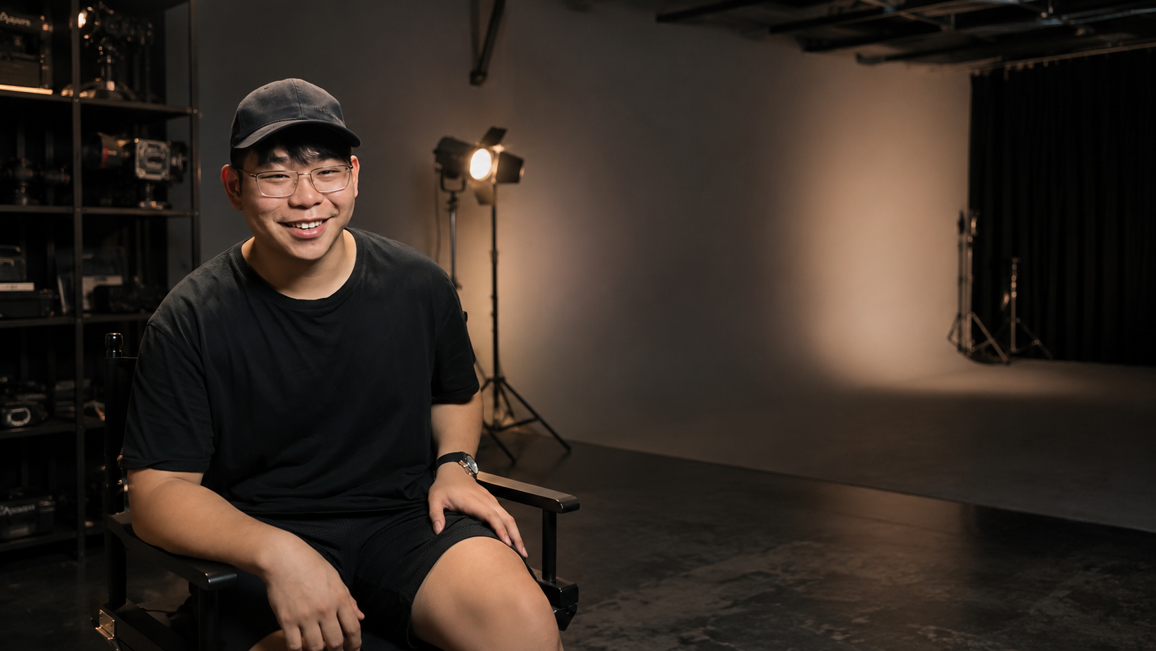 Michael Lim seated in a film studio with cameras and lighting equipment